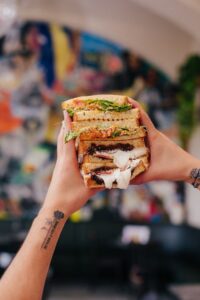 A creator showing off a huge sandwich